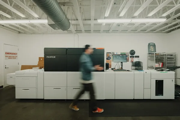 Person passing in front of a Fujifilm Press